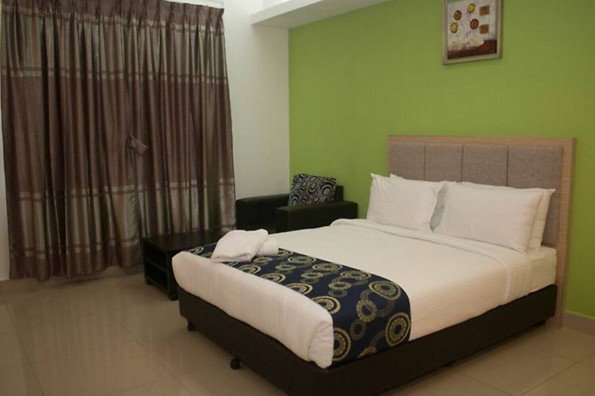 A bedroom with a bed, a nightstand, a chair, and a curtain.
