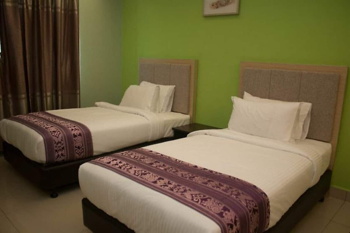 Two single beds with headboards, a green wall, and a curtain.