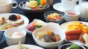 Une table dressée avec différents plats, notamment du riz, des légumes et de la viande.