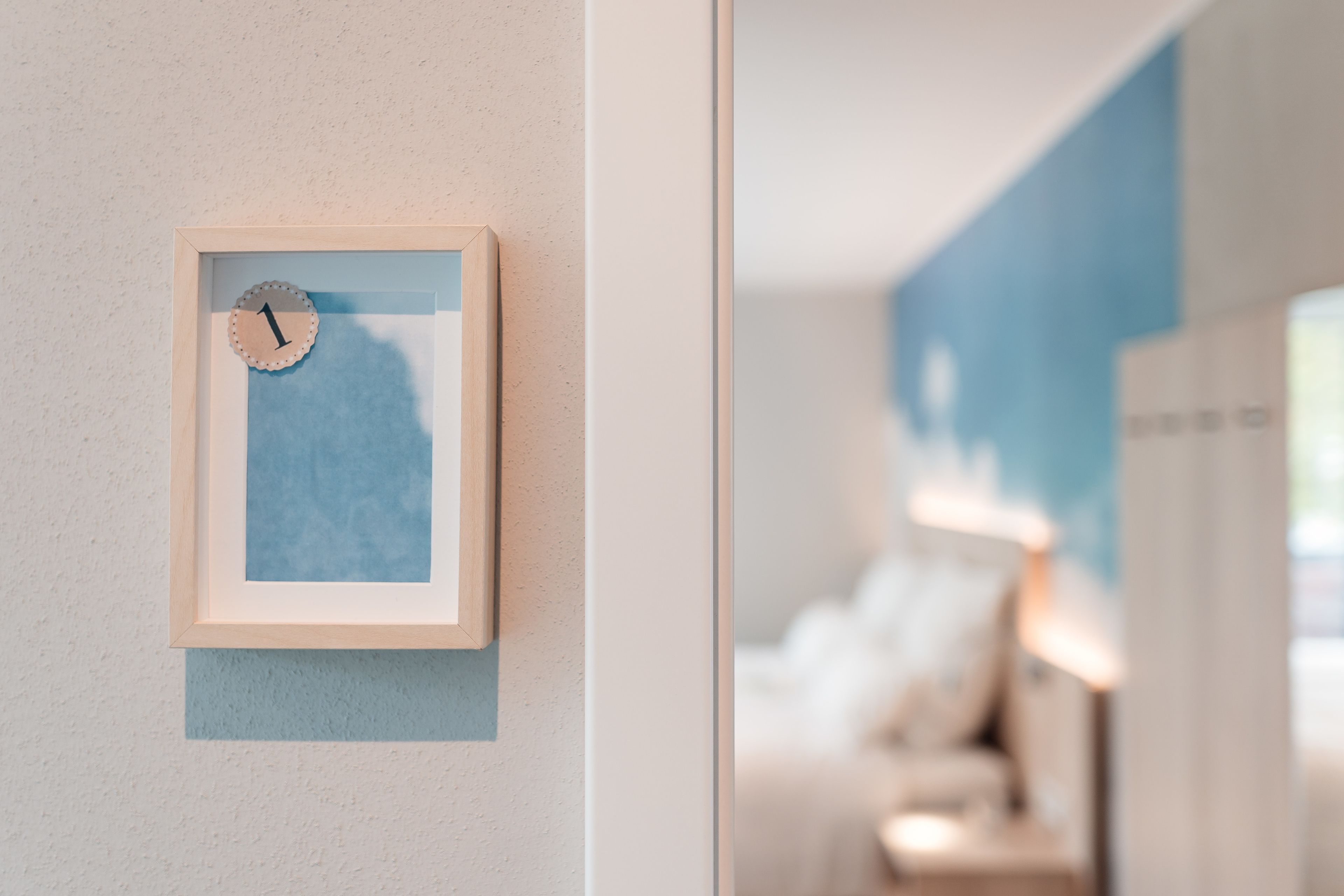 A framed clock with a blue background on a wall.