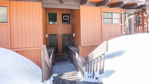 Eine Holzhütte mit einer Holzterrasse und einer Tür mit einem Fenster darüber.