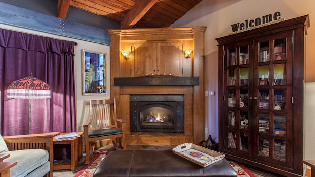 Ein gemütliches Wohnzimmer mit Kamin, Holzmöbeln und einer Bücherwand.
