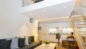 Een modern appartement met een woonkamer, keuken en een trap.