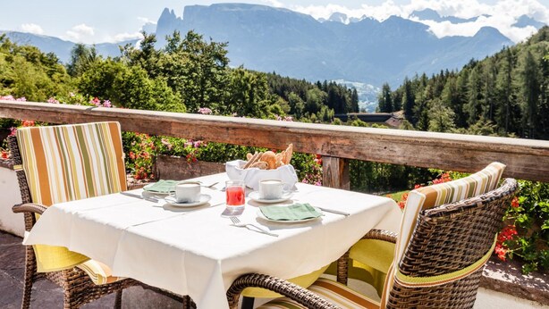 Una mesa preparada para el desayuno con vistas a la montaña.