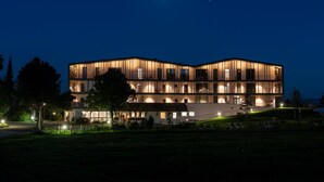 Un hotel de varios pisos con diseño moderno, con balcones y ventanas amplias.