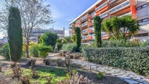 A residential building with balconies, surrounded by a landscaped garden with various plants and a stone pathway. - Le Maxime by Interhome (Sainte Maxime)