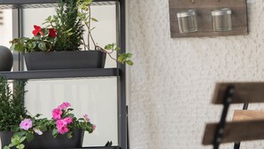 Ein modernes Interieur mit einer Metallregaleinheit, auf der verschiedene Blumentöpfe und Blumen stehen.