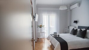 Ein modernes Schlafzimmer mit Bett, Nachttisch und einem kleinen Schreibtisch mit Stuhl.