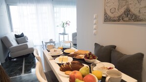 Ein Essbereich mit einem Tisch, gedeckt für das Frühstück, inklusive Früchte, Brot und Getränke.