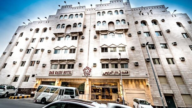 Un grand hôtel à plusieurs étages, doté d’une entrée imposante et d’une enseigne bien visible indiquant « Dar Raies Hotel ».