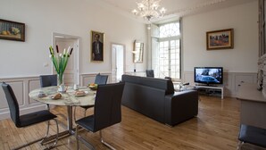 A modern living room with a marble table, black leather sofas, and a television. - APARTMENT OF STANDING THE GENIS (Sarlat-la-Canéda)