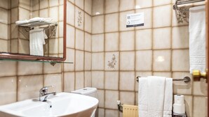 Ein Badezimmer mit Waschbecken, Toilette und Handtuchhalter.