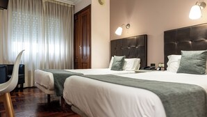 A hotel room with two beds, a desk, and a chair. - Alda Centro Pontevedra (Pontevedra)