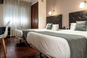 A hotel room with two beds, a desk, and a chair. - Alda Centro Pontevedra (Pontevedra)