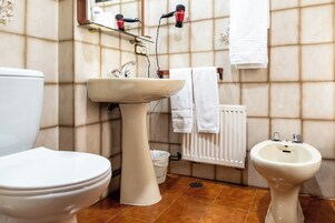 A bathroom with a toilet, sink, and bidet.