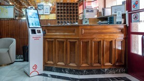 Ein Empfangsbereich mit Holztresen, einem digitalen Kiosk und einem Schild, das kostenloses WLAN anzeigt.