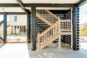 Una escalera de madera con barandilla de metal, que conduce a un nivel superior.