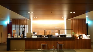 A reception desk with a wooden finish, a first cabin sign, and a digital AED display. - First Cabin Haneda Terminal 1 (Tokyo)
