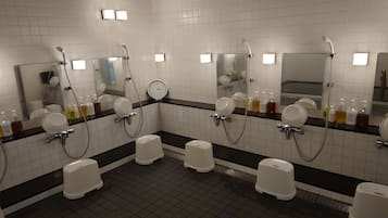 A public restroom with multiple urinals, hand dryers, and a clock on the wall.