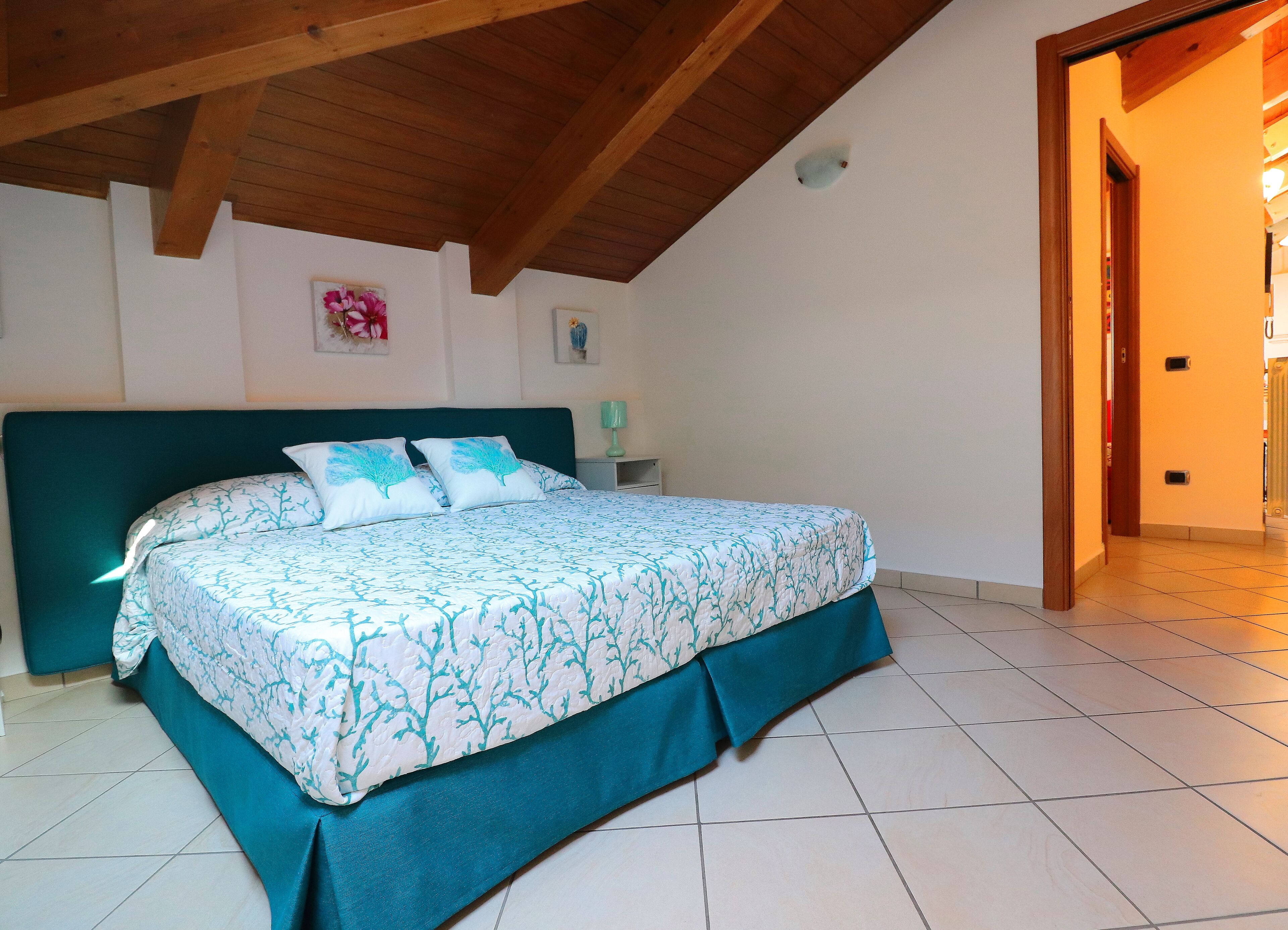 Une chambre à coucher avec un lit, une table de chevet et un luminaire fixé au mur.