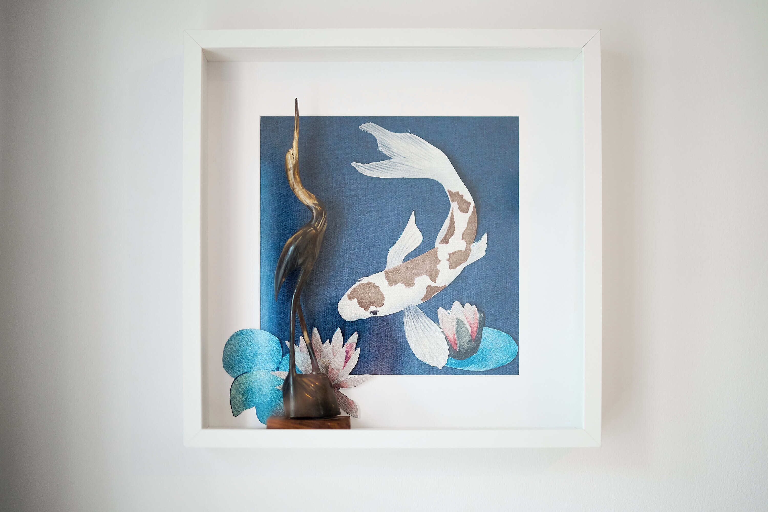 A framed artwork of koi fish and lotus flowers.
