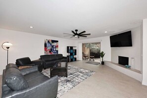 A modern living room with a sofa, coffee table, and a TV mounted on the wall.