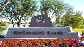 A sign with the text "McCormick Ranch" and a logo, surrounded by trees and flowers.