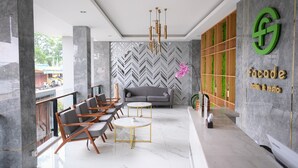 A modern lobby with marble flooring, a sofa, and a reception desk. - Facade Hotel by Azana (Tawangmangu)