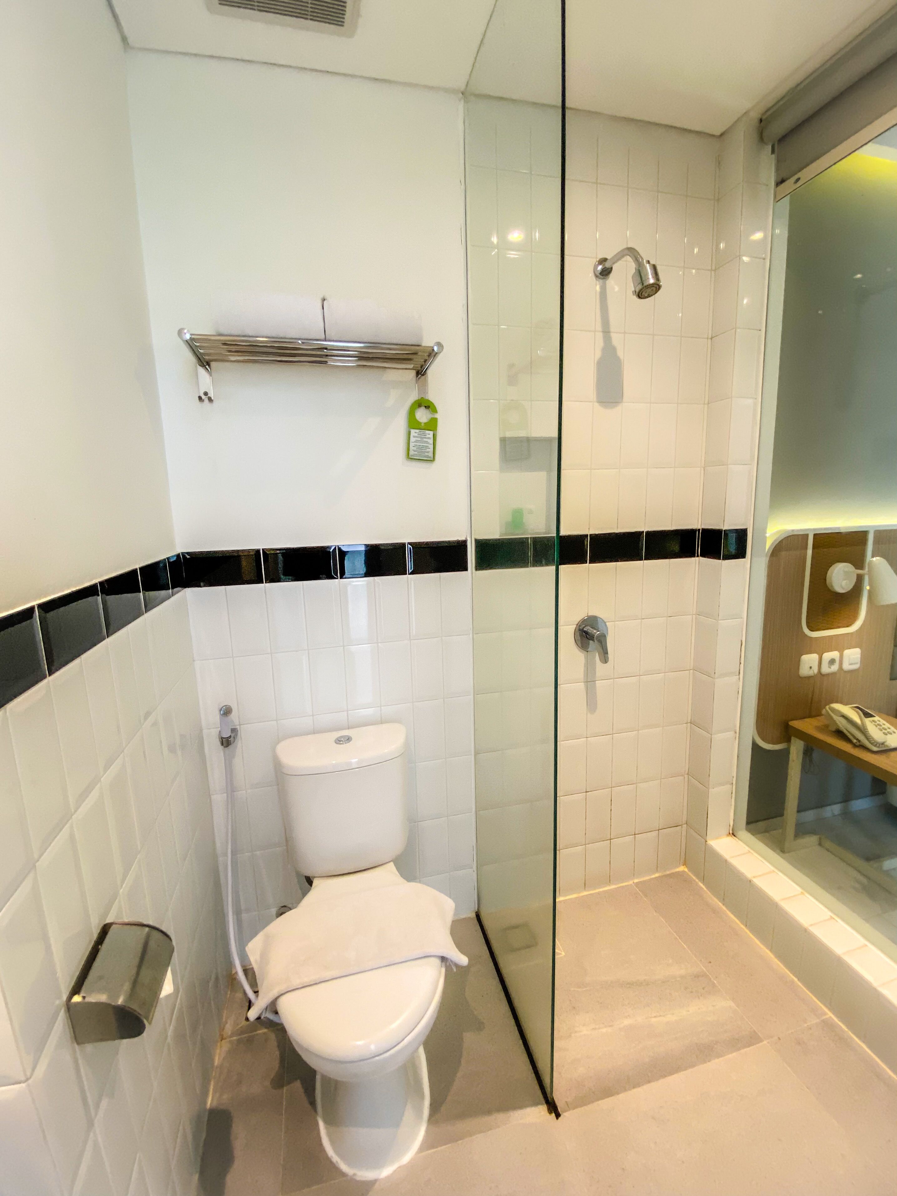 A bathroom with a toilet, a glass shower enclosure, and a bathtub.