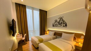 A hotel room with two beds, a desk, a chair, and a wall-mounted TV. - Facade Hotel by Azana (Tawangmangu)