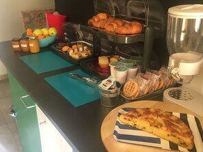 A breakfast buffet with pastries, fruits, and a waffle. - Interno 10 (Syracuse)