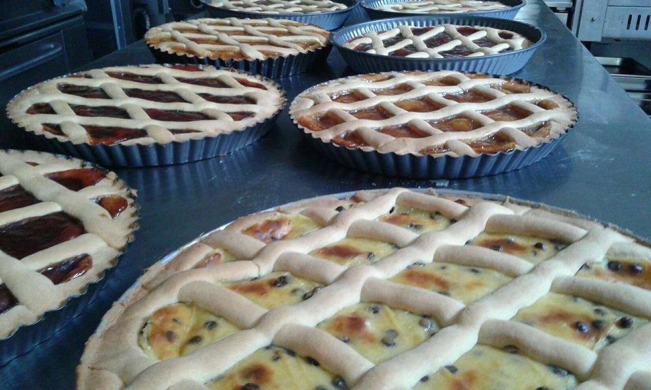 A variety of pies in baking pans on a kitchen counter.