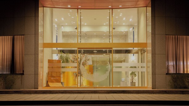 A modern building entrance with glass doors, a reception desk, and a sign indicating 'Information.' - Shionomaru (Imabari)
