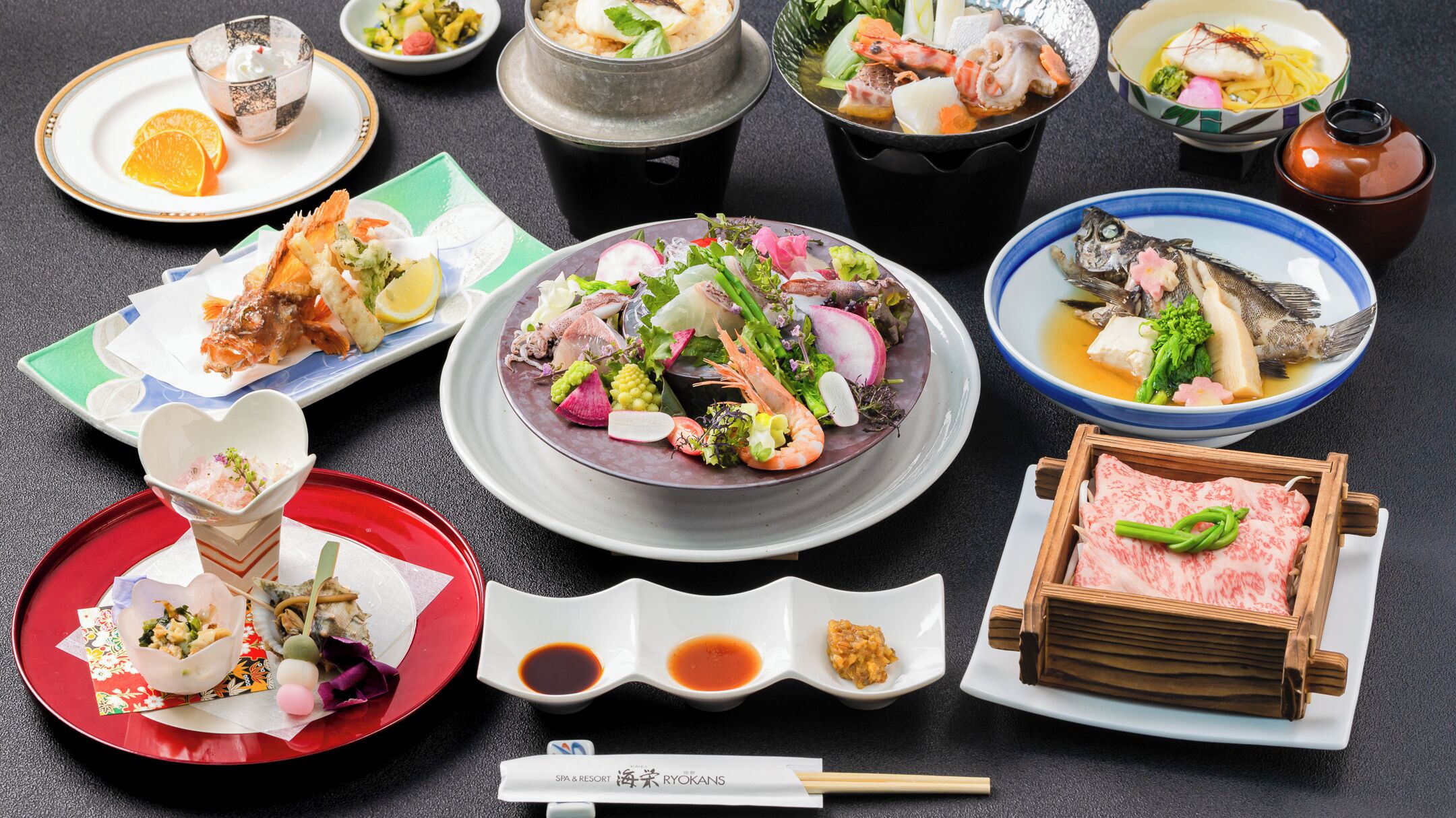 A variety of Japanese dishes, including sushi, sashimi, and a bowl of fish with vegetables.