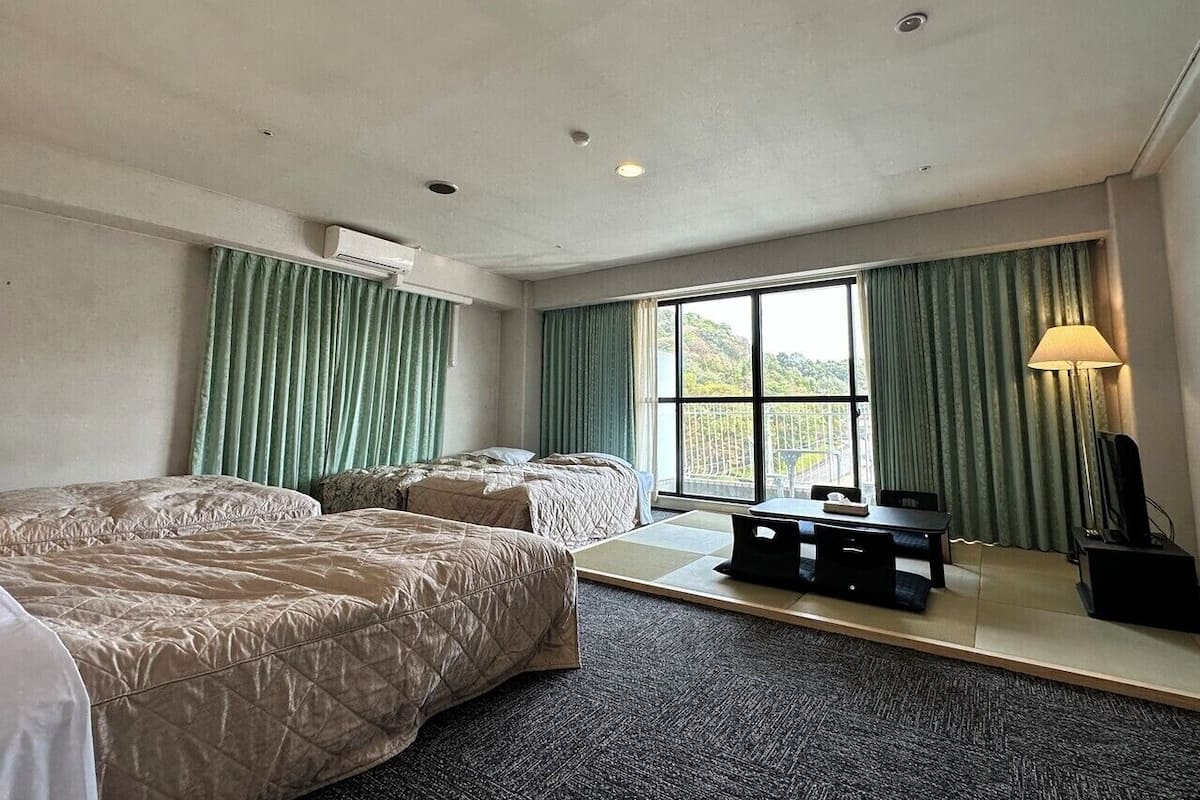 Habitación cuádruple Deluxe | Escritorio, cortinas blackout, wifi gratis y ropa de cama