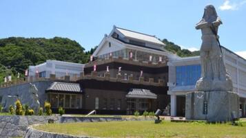 Een traditioneel Japans gebouw met een groot standbeeld ervoor.