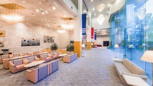 A spacious lobby with seating, a reception desk, and large windows offering a view of the outdoors. - Shionomaru (Imabari)