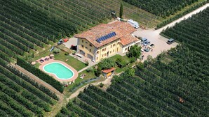 An aerial view of a property with a swimming pool, solar panels, and a large building surrounded by agricultural fields. - Agriturismo La Molinalda (Castelnuovo del Garda)