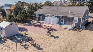 A two-story house with a covered patio area, a fire pit, and outdoor seating. - Three bedroom duplex less than 500 ft to the shared/private beach (West Dennis)