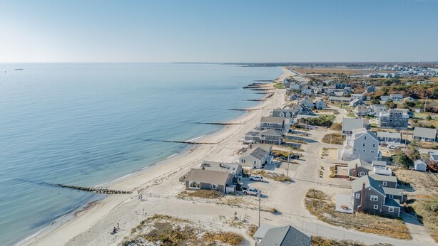 A coastal residential area with houses along the beach, a clear sky, and calm sea. - Three bedroom duplex less than 500 ft to the shared/private beach (West Dennis)