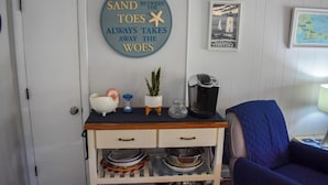 A kitchen area with a coffee maker, a small plant, and a decorative sign on the wall. - Three bedroom duplex less than 500 ft to the shared/private beach (West Dennis)