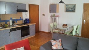 Un ambiente compatto con angolo cottura, zona pranzo e salotto.