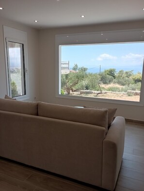 Deluxe Apartment, 1 Bedroom, Sea View | Living area | 32-inch flat-screen TV with digital channels, TV - Agriomata Vergas Apartments (Kalamata)