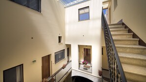 Un intérieur à plusieurs niveaux, doté d’un escalier, de balcons et d’une verrière.