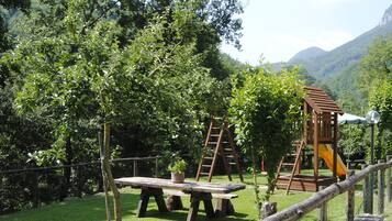 A playground with wooden structures and a picnic table.