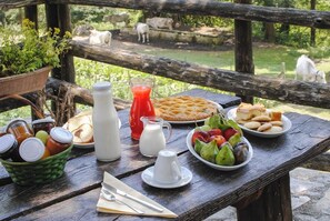 A picnic table with food, a jug of milk, and a basket of jars. - Agriturismo La Ferrera (Varco Sabino)