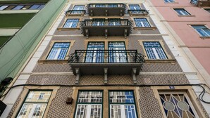 Un edificio de varios pisos con fachada ornamentada, balcones y ventanas amplias.