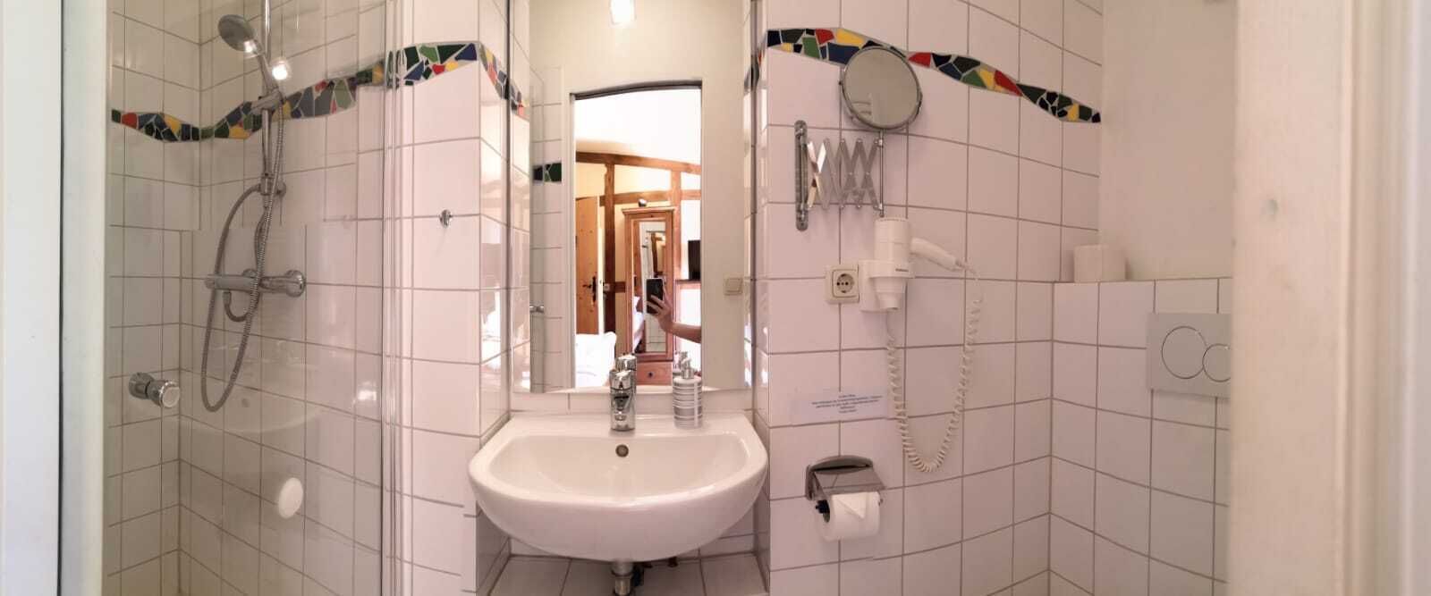 A bathroom with a shower, sink, and toilet.