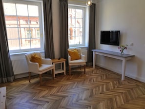 Appartement Deluxe | Coin séjour | Télévision à écran plat, baby-foot, table de tennis de table, livres