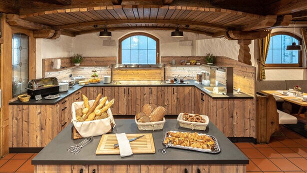 A breakfast buffet with bread, pastries, and utensils. - Hotel Alter Hof (Vaterstetten)